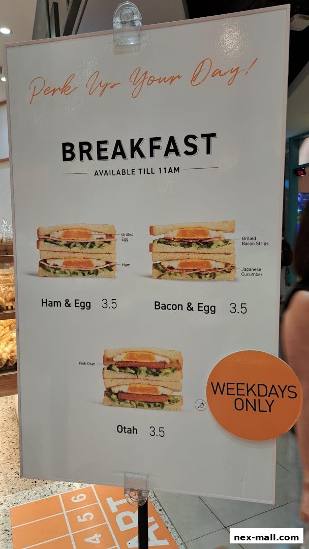 A breakfast menu board featuring sandwiches like Ham & Egg, Bacon & Egg, and Otah.