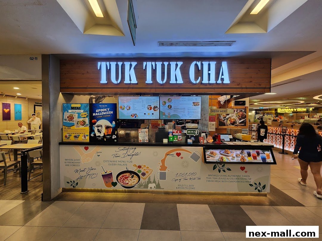 The front of a Tuk Tuk Cha shop with menus and promotional posters displayed.