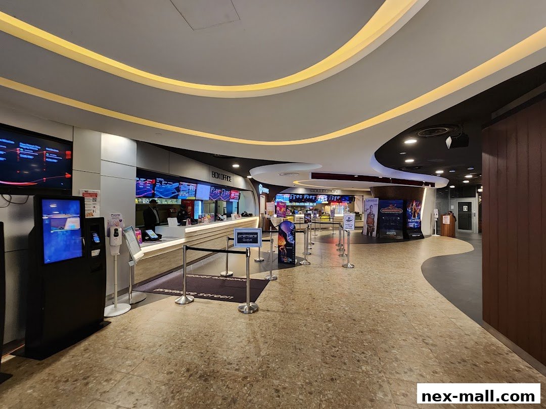 The interior of a modern cinema lobby with a box office and movie posters.
