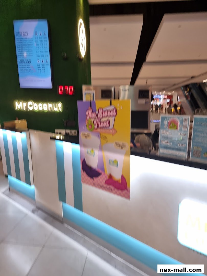 The Mr. Coconut NEX shop counter with a digital menu and promotional posters.