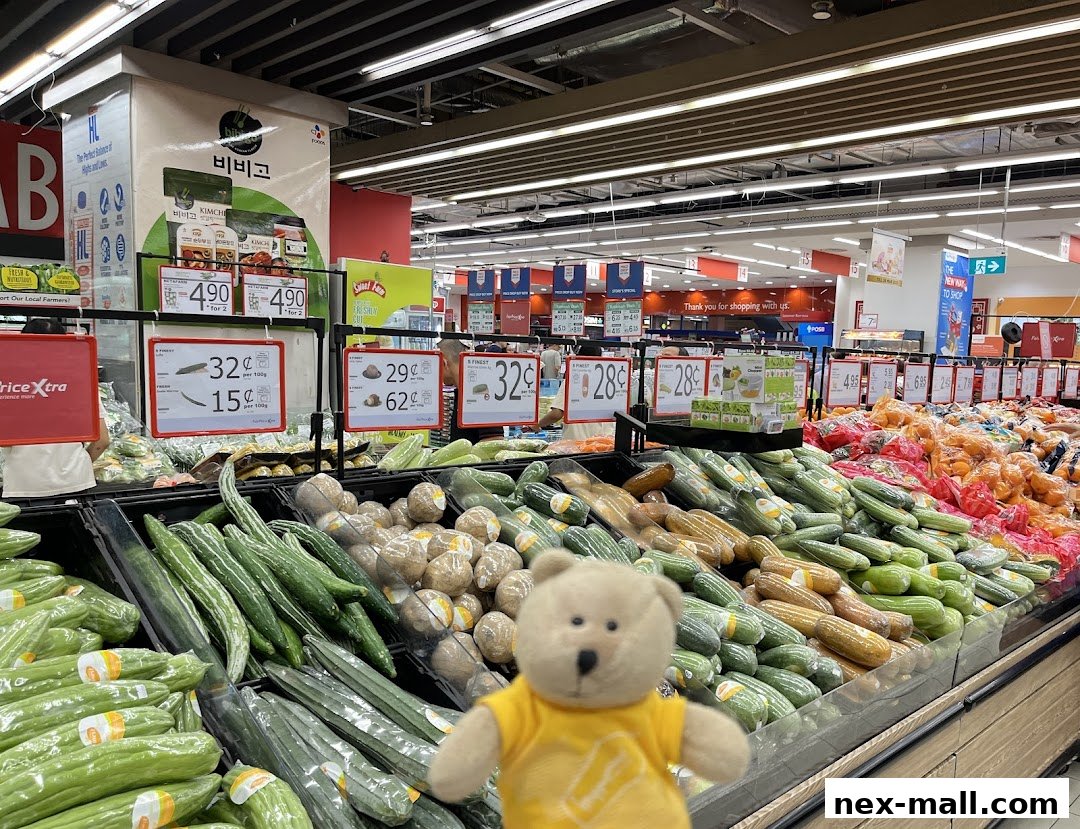 A teddy bear poses in front of a produce display at FairPrice Xtra NEX supermarket.