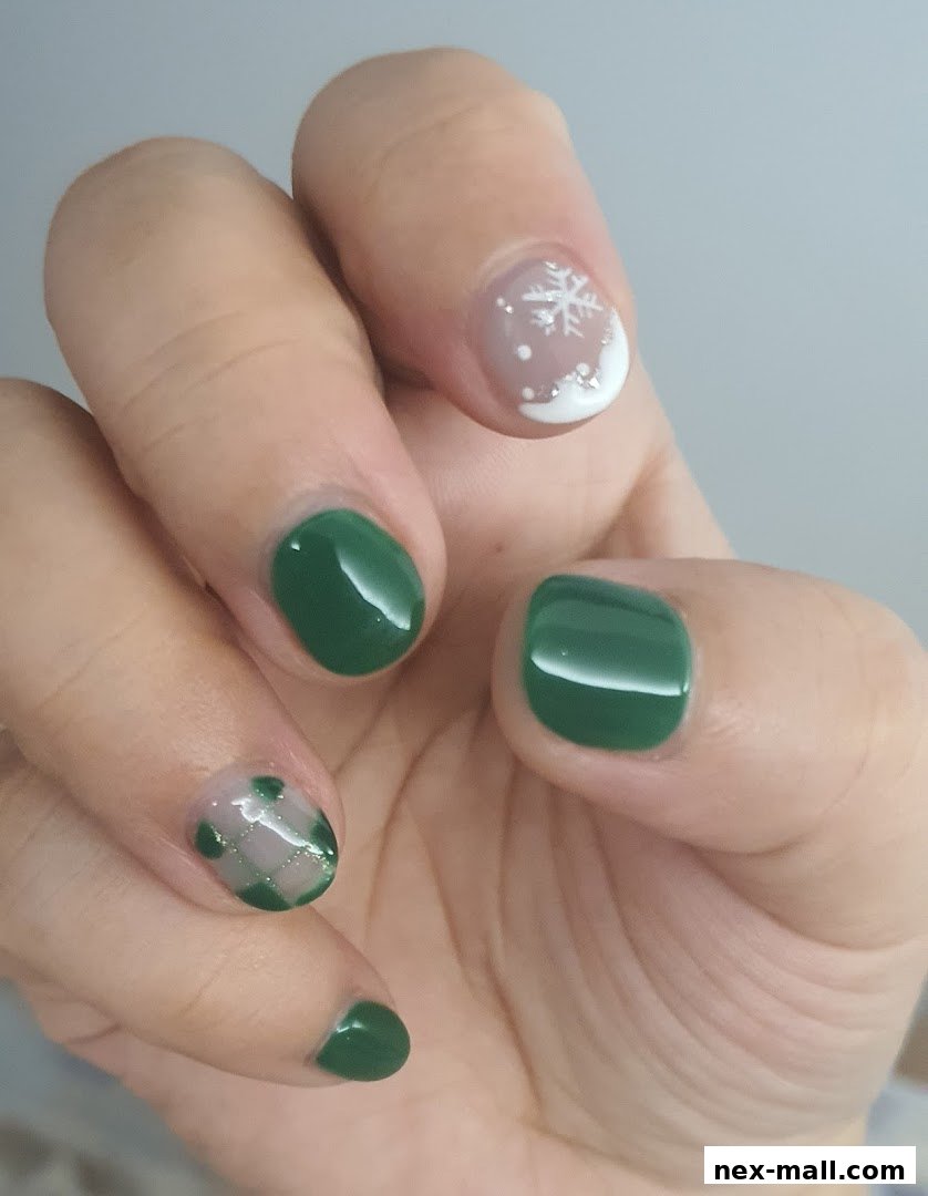 A close-up of a hand with festive green and snowflake-themed nail art.
