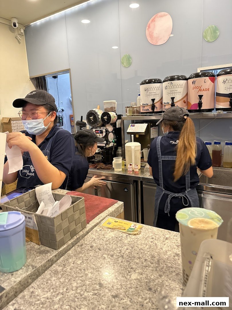 Staff preparing drinks behind a counter at PlayMade, a beverage shop.