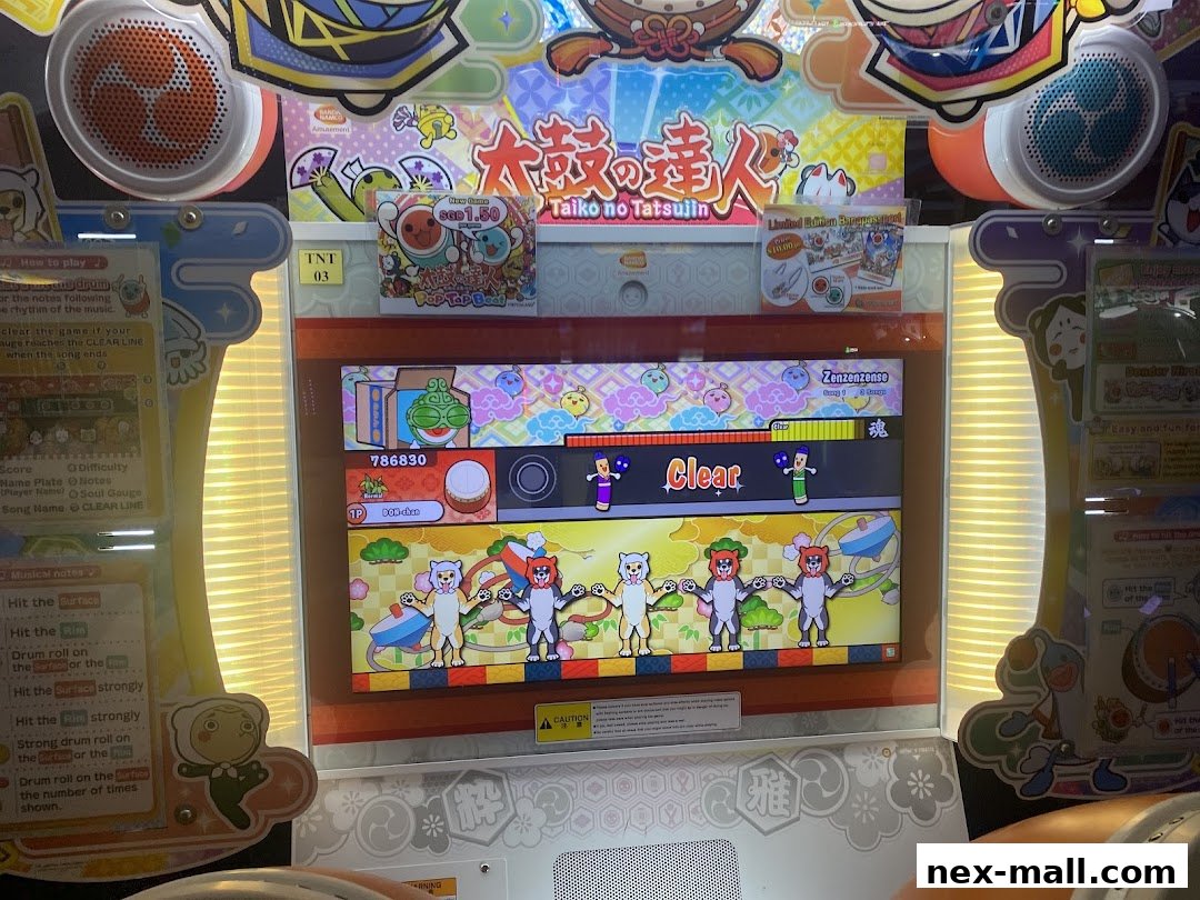 A Taiko no Tatsujin arcade game machine displaying a 'Clear' screen with characters.