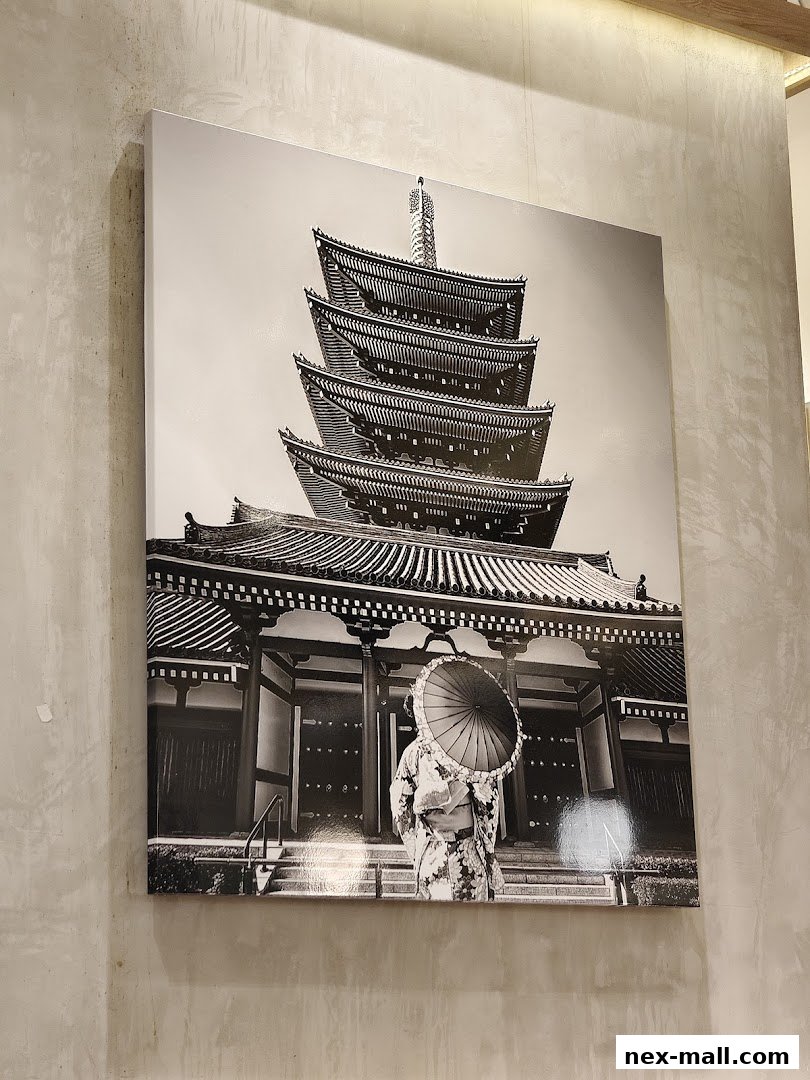 A black and white photograph of a Japanese pagoda with a person in traditional attire holding an umbrella.