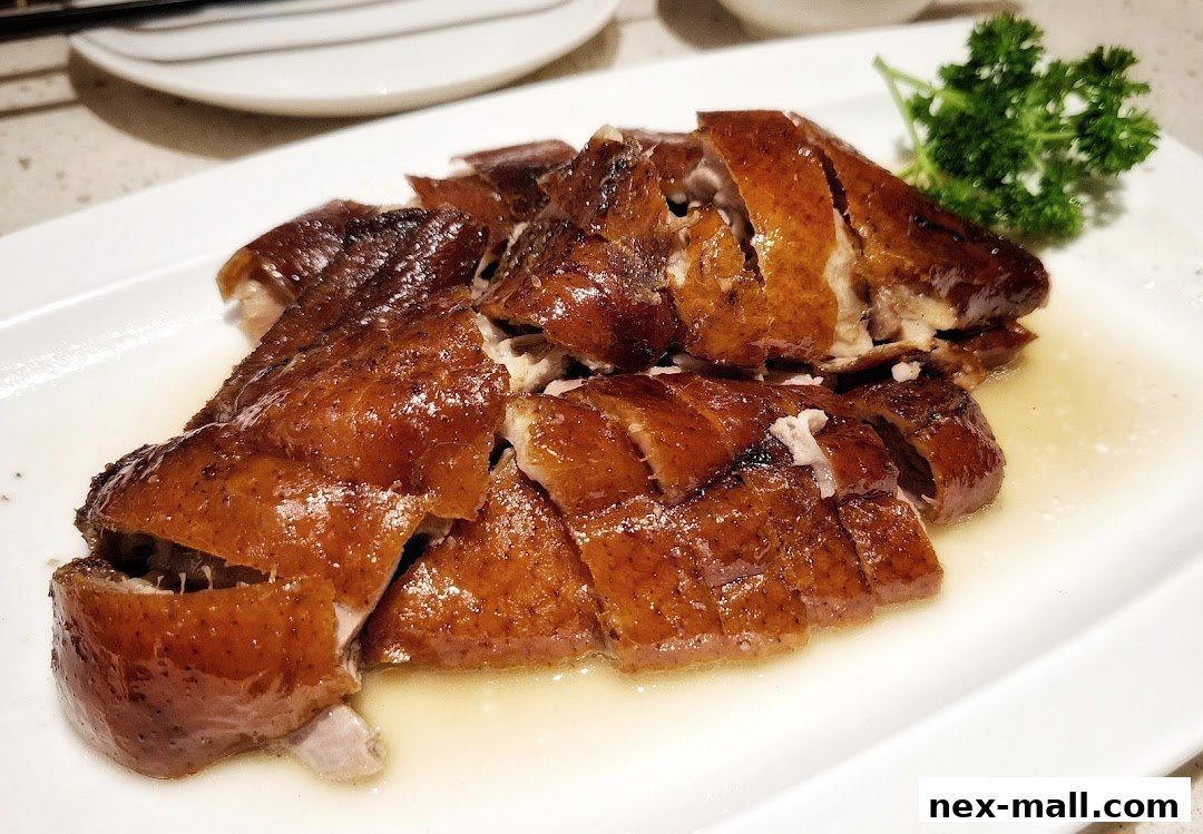 A plate of succulent, crispy roasted duck, garnished with parsley.