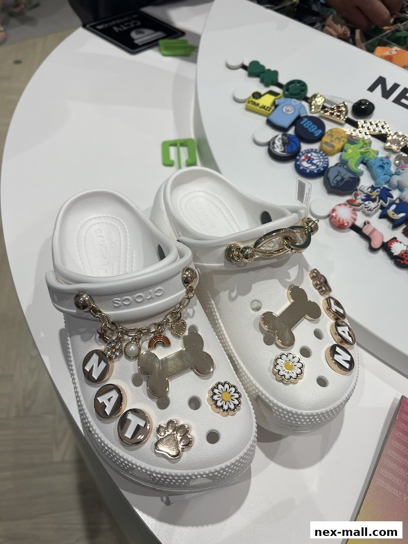 White Crocs decorated with charms and letters on display.