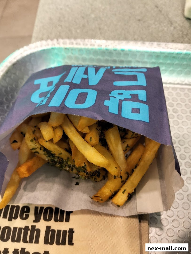 A close-up of a paper bag filled with crispy fries seasoned with herbs.
