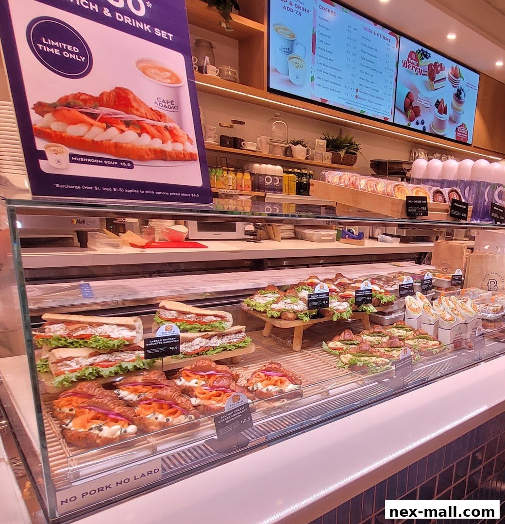 A display case filled with fresh sandwiches and croissants at Paris Baguette NEX.