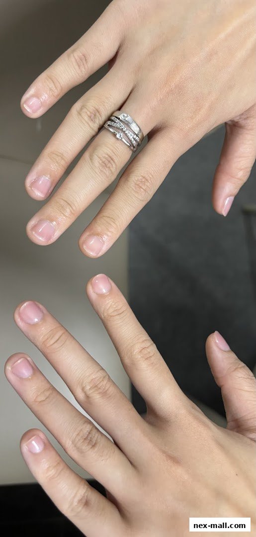 Close-up of two hands, one wearing a silver ring with small diamonds.