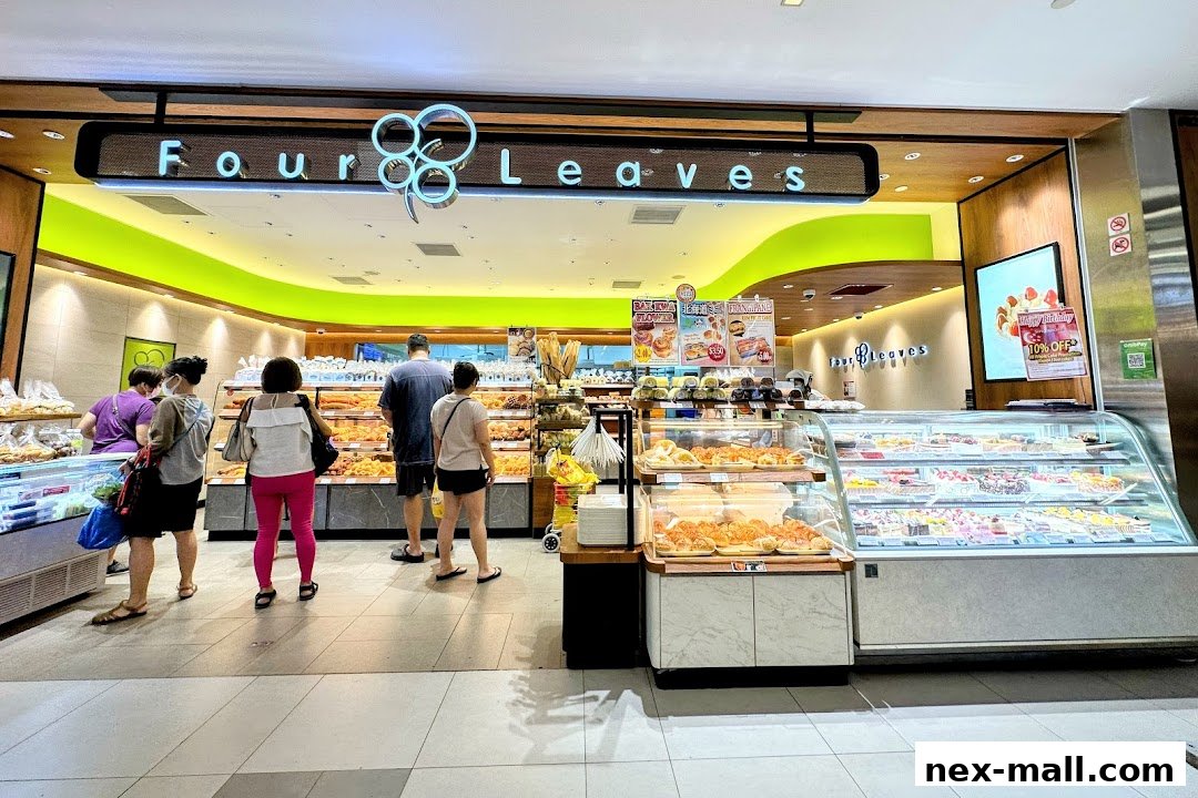 Customers browse a bakery display filled with pastries and cakes at Four Leaves.