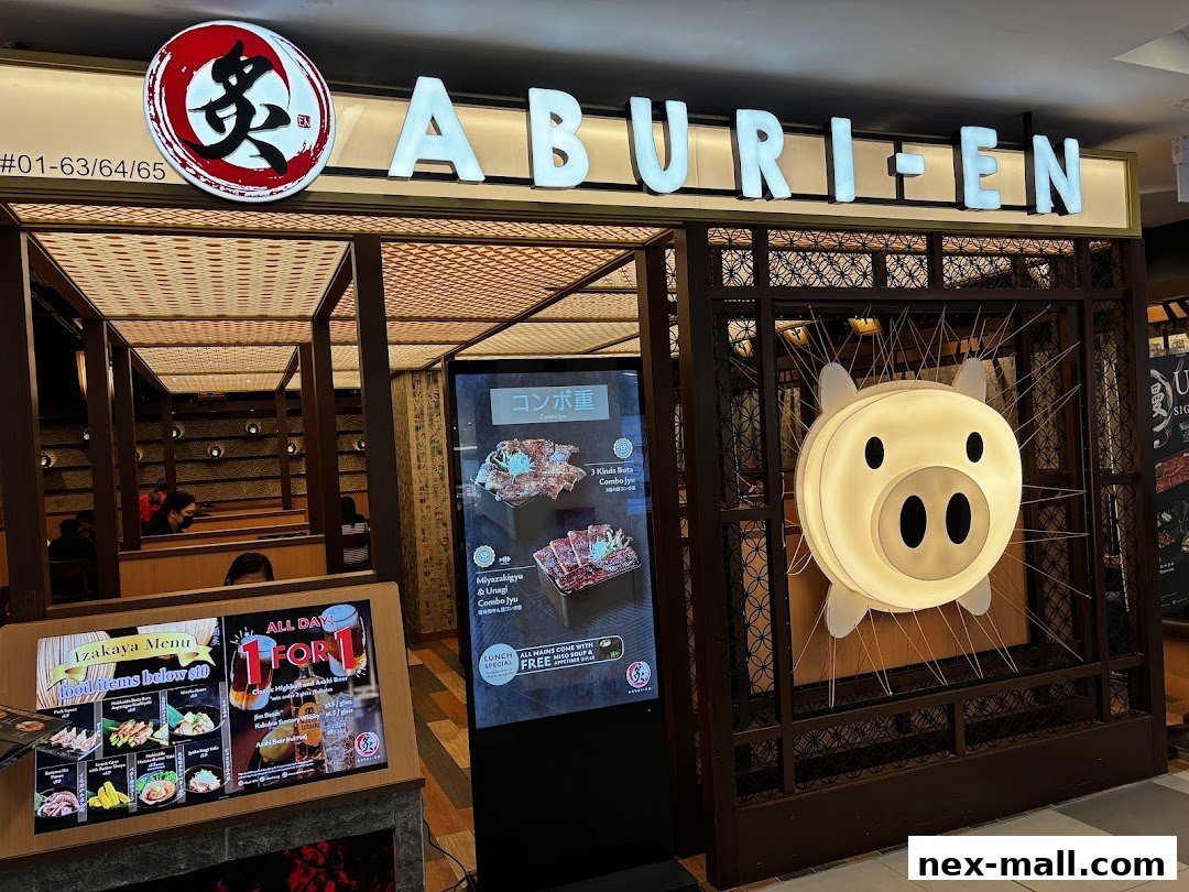 The entrance of Aburi-EN Nex, a Japanese restaurant with a prominent sign and a pig-shaped light.