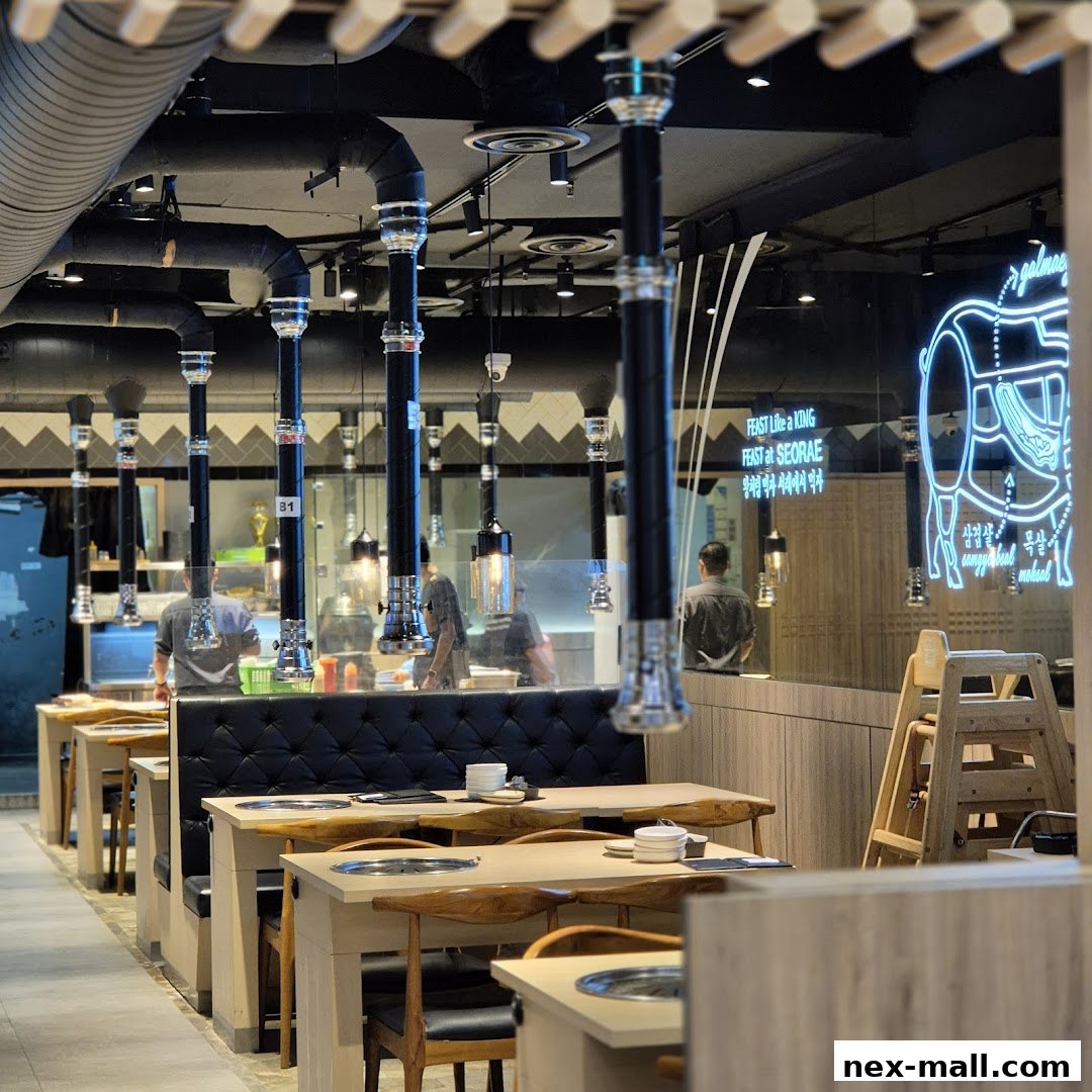 Interior of a Korean BBQ restaurant with tables, seating, and ventilation hoods.