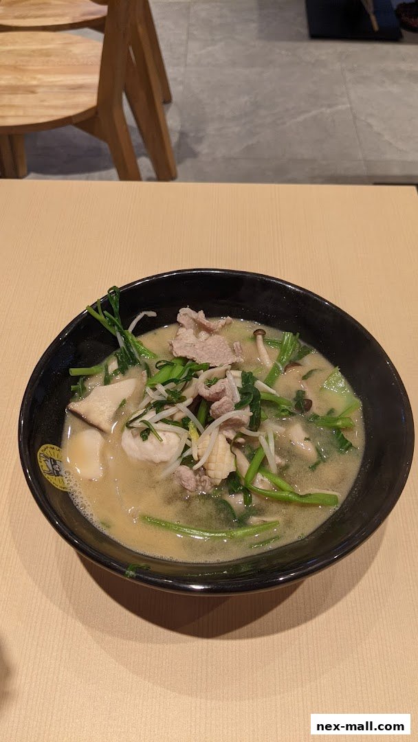A steaming bowl of Mala Tang with pork, vegetables, and mushrooms.