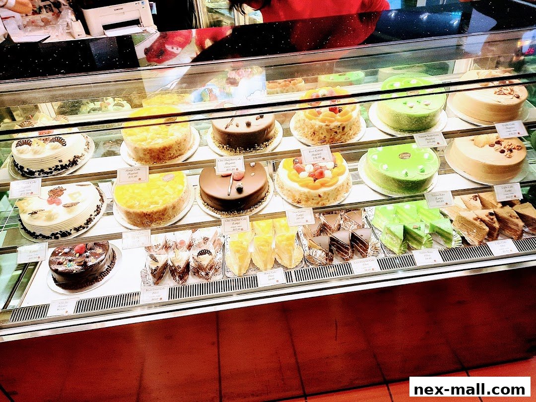 A display case filled with a variety of beautifully decorated cakes and pastries.