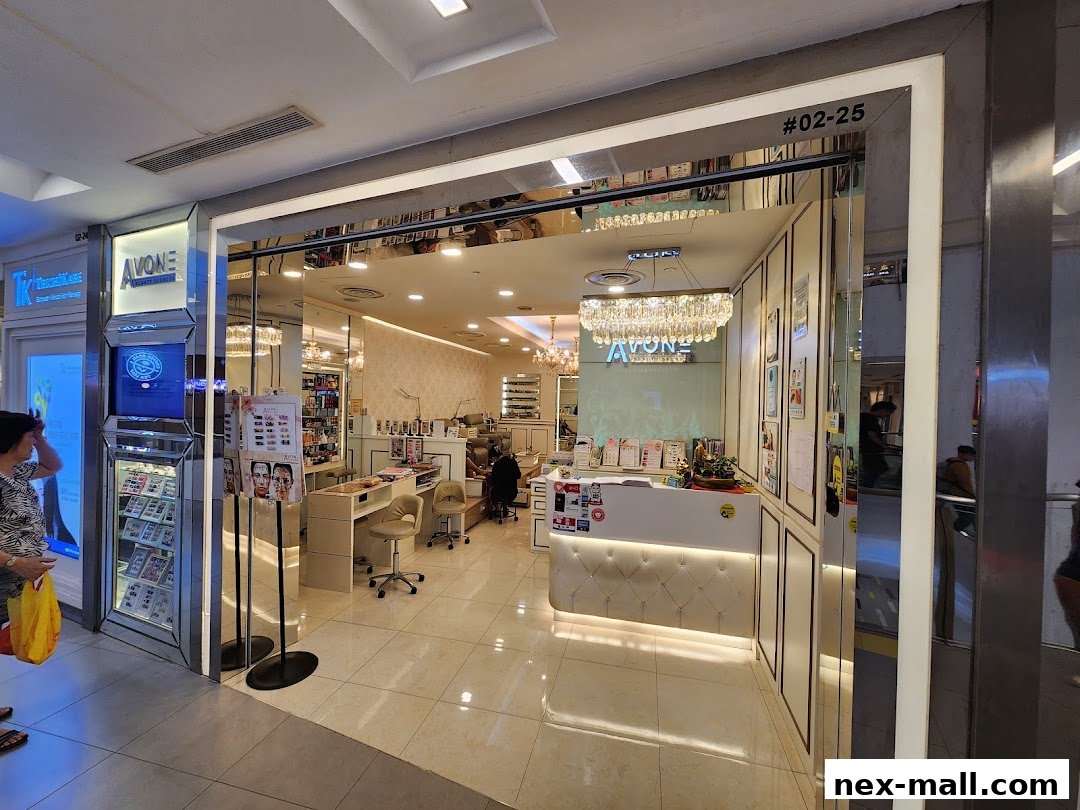 Interior view of a modern beauty and nail salon with a reception desk and manicure stations.