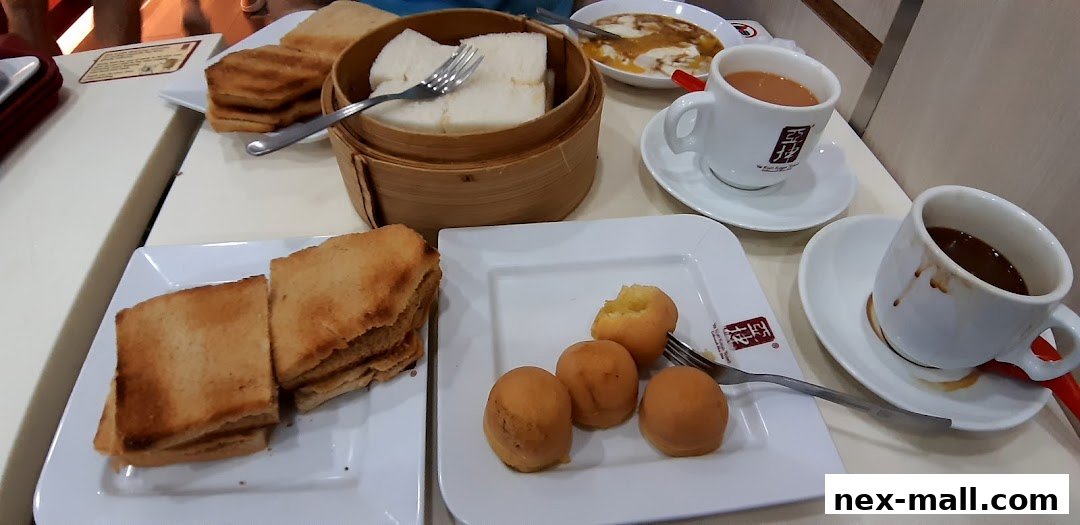 A table laden with Ya Kun Kaya Toast's signature dishes, including kaya toast, soft-boiled eggs, and coffee.