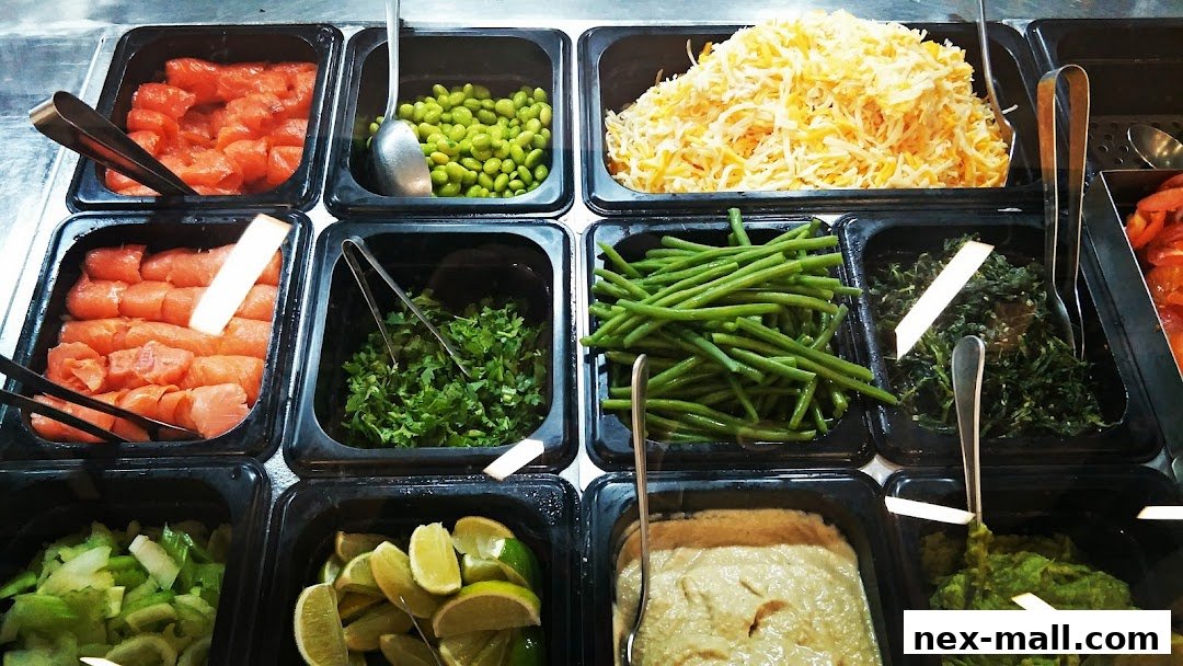 A variety of fresh ingredients, including salmon, edamame, cheese, and vegetables, displayed in containers.