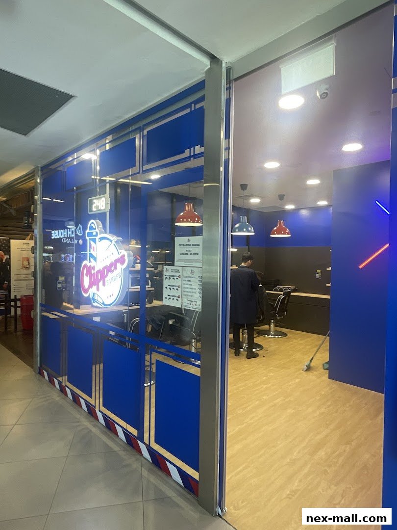 The entrance to Clippers Barber shop, showcasing its modern interior and barber chairs.