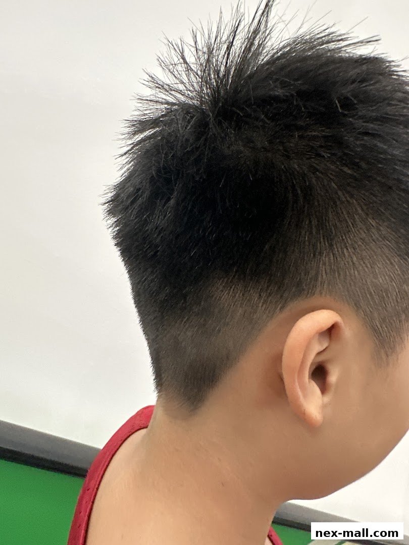 Close-up of a person's head showing a stylish fade haircut with spiky top.