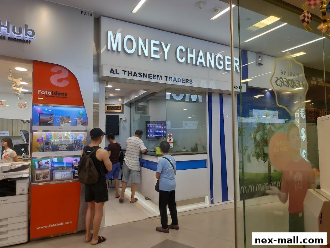The exterior of AL Thasneem Traders Money Changer shop with customers inside.