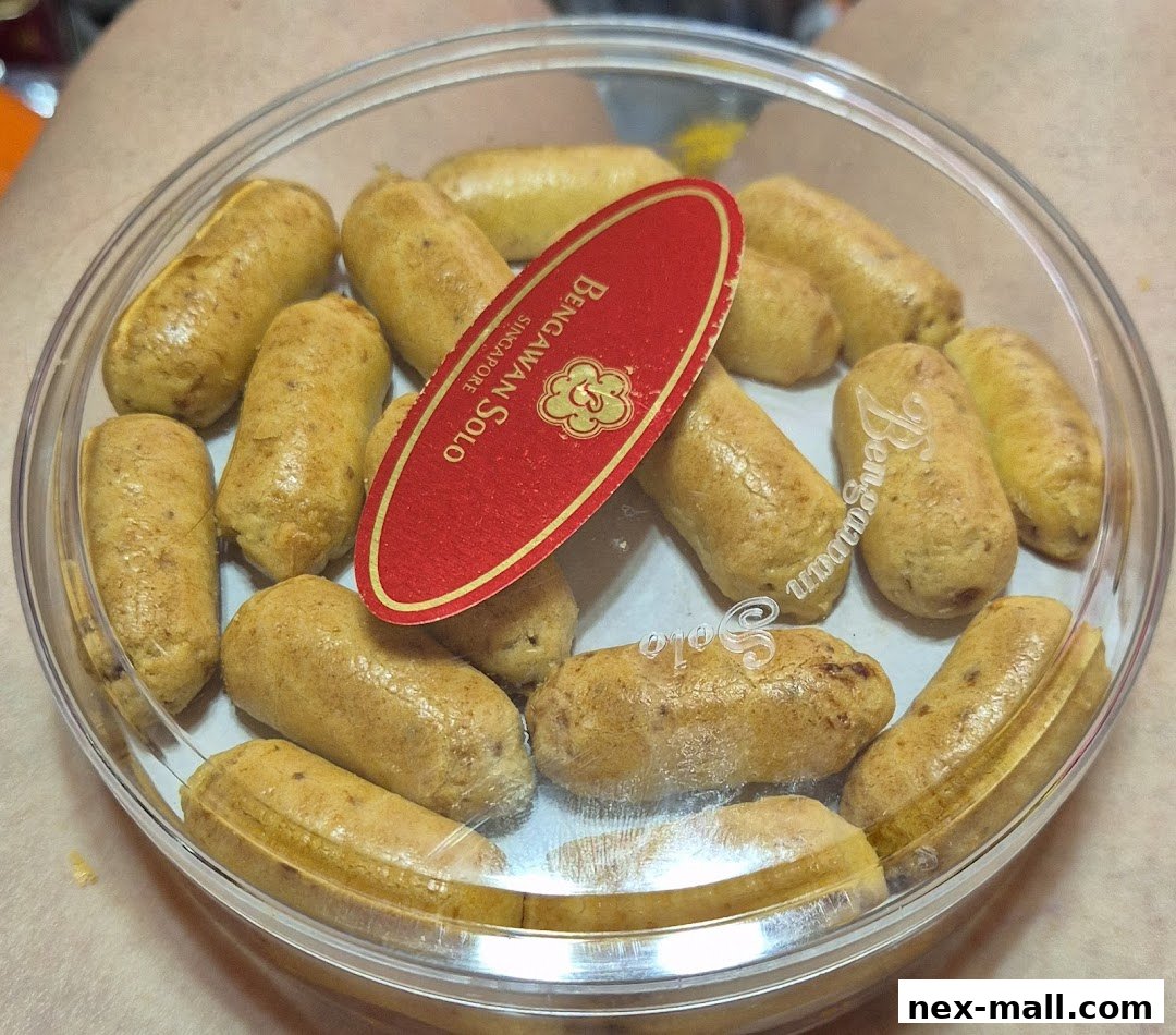 A clear plastic container filled with golden-brown, sausage-shaped cookies from Bengawan Solo.