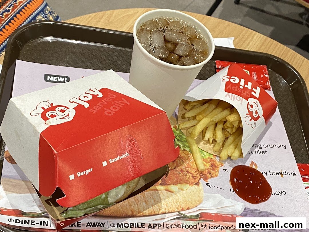 A Jollibee meal featuring a burger, fries, a drink, and ketchup on a tray.
