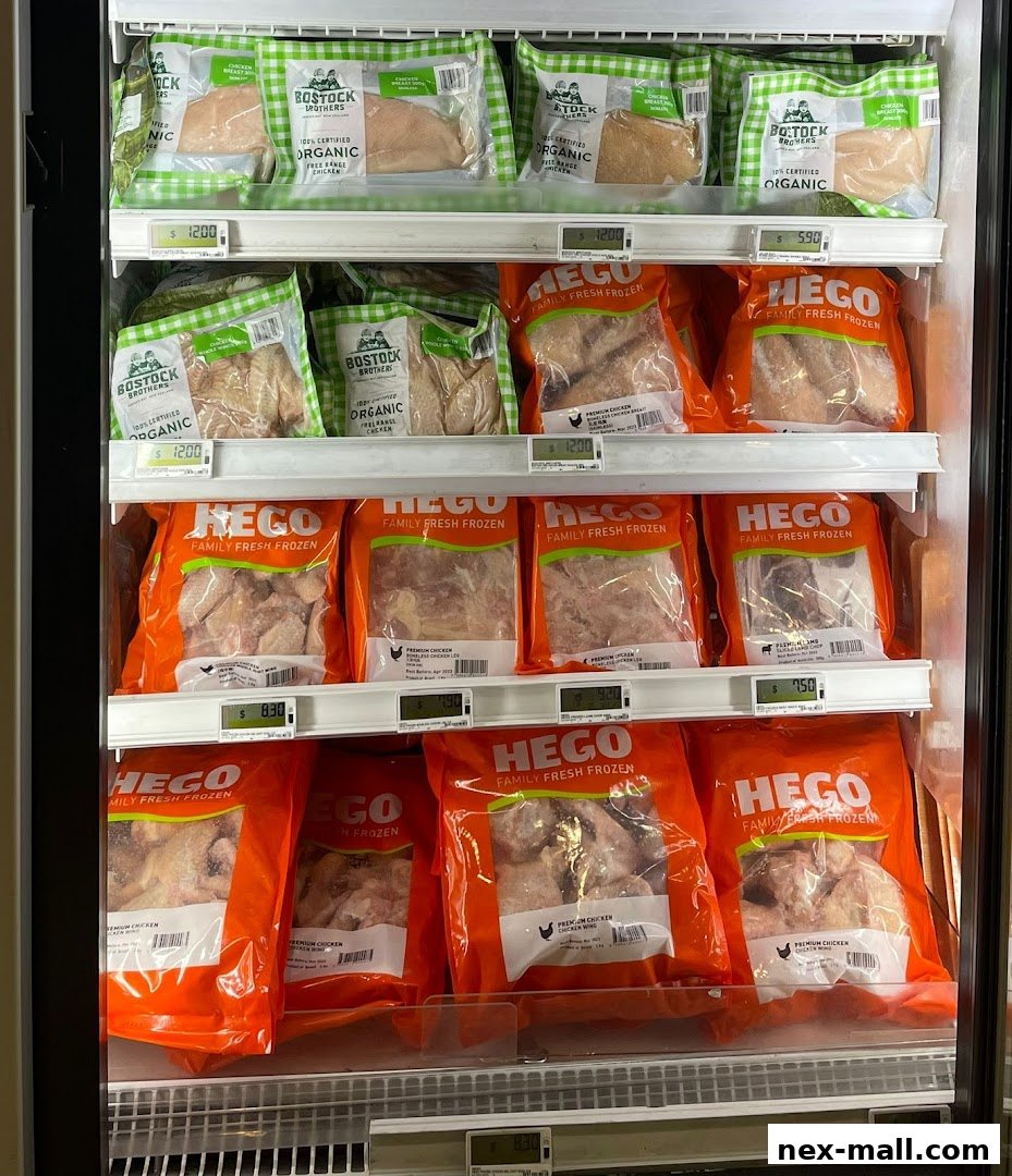 A refrigerated display case filled with various packages of fresh and frozen chicken and lamb.