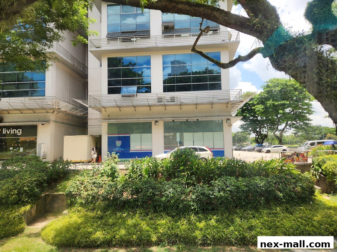 Exterior view of a modern building with shops and greenery in the foreground.