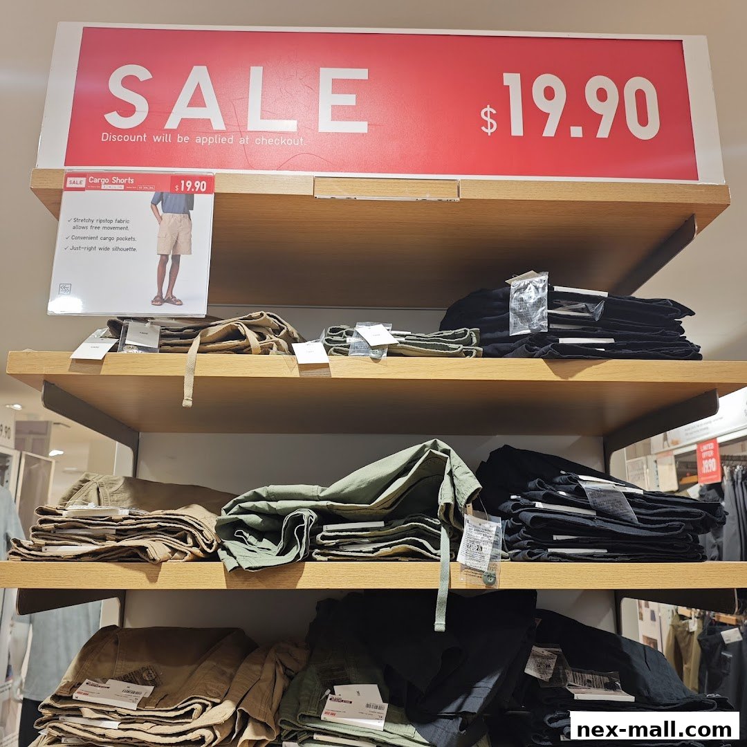 Shelves stocked with folded cargo shorts in various colors, with a prominent sale sign.