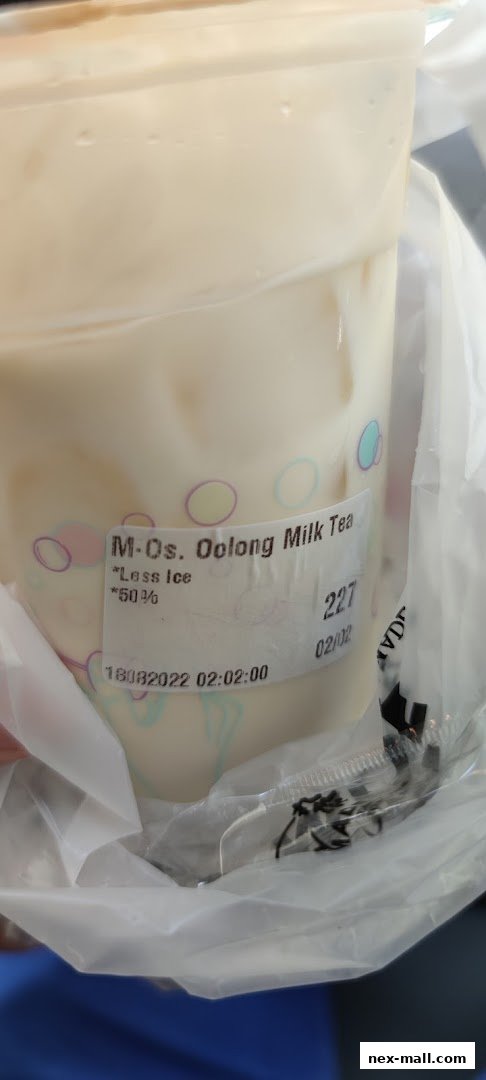 A close-up of a PlayMade Oolong Milk Tea with less ice, showing order details.