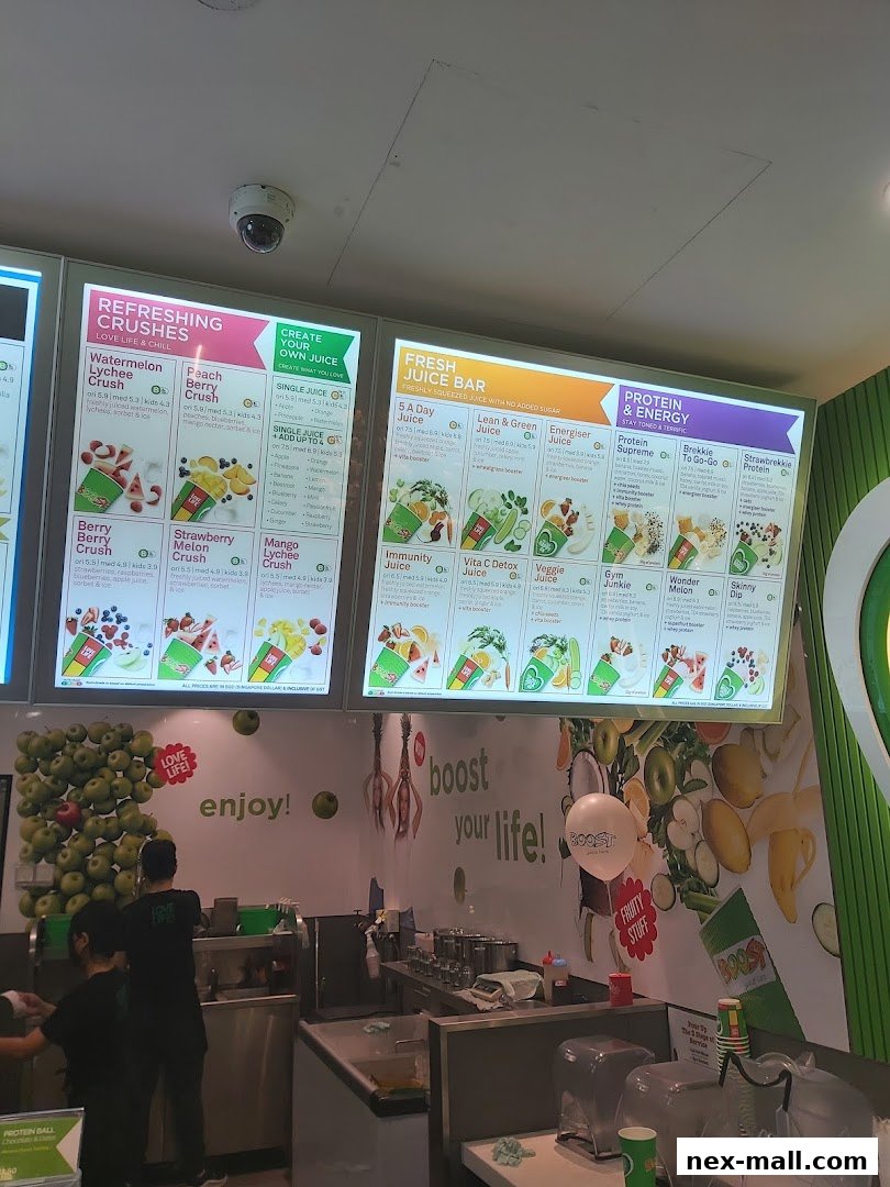 A brightly lit menu board displaying various juice and smoothie options at Boost Juice.
