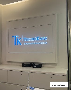 The interior of a hair treatment salon with the TK TrichoKare logo prominently displayed.