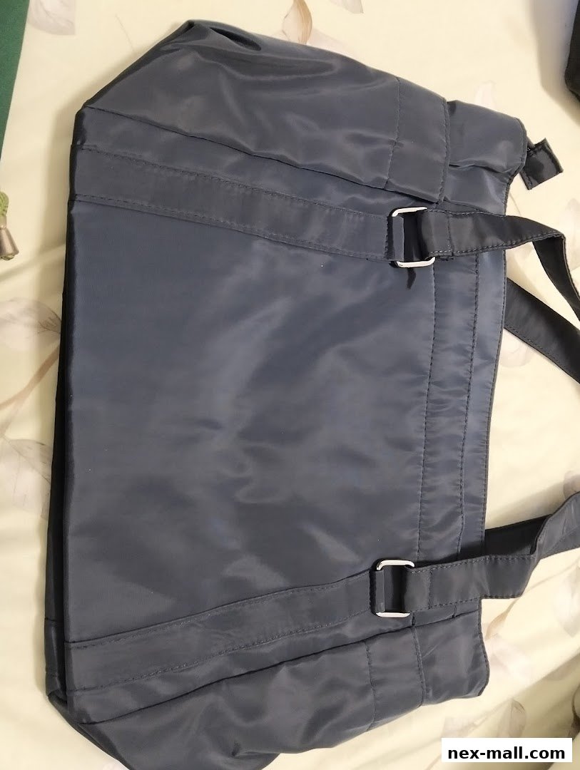 A close-up view of a stylish, dark grey tote bag with adjustable straps and silver buckles.