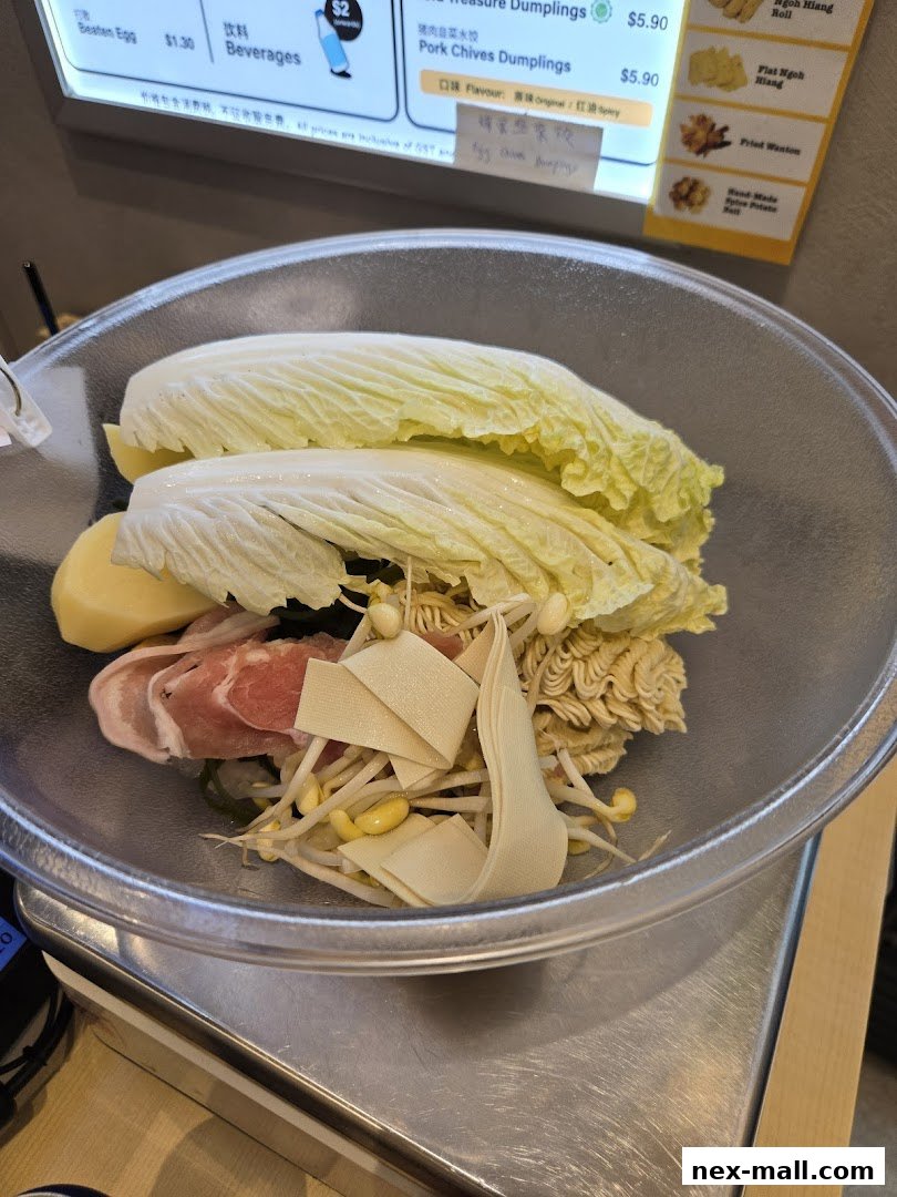 A bowl of ingredients for Mala Tang with a menu board in the background.