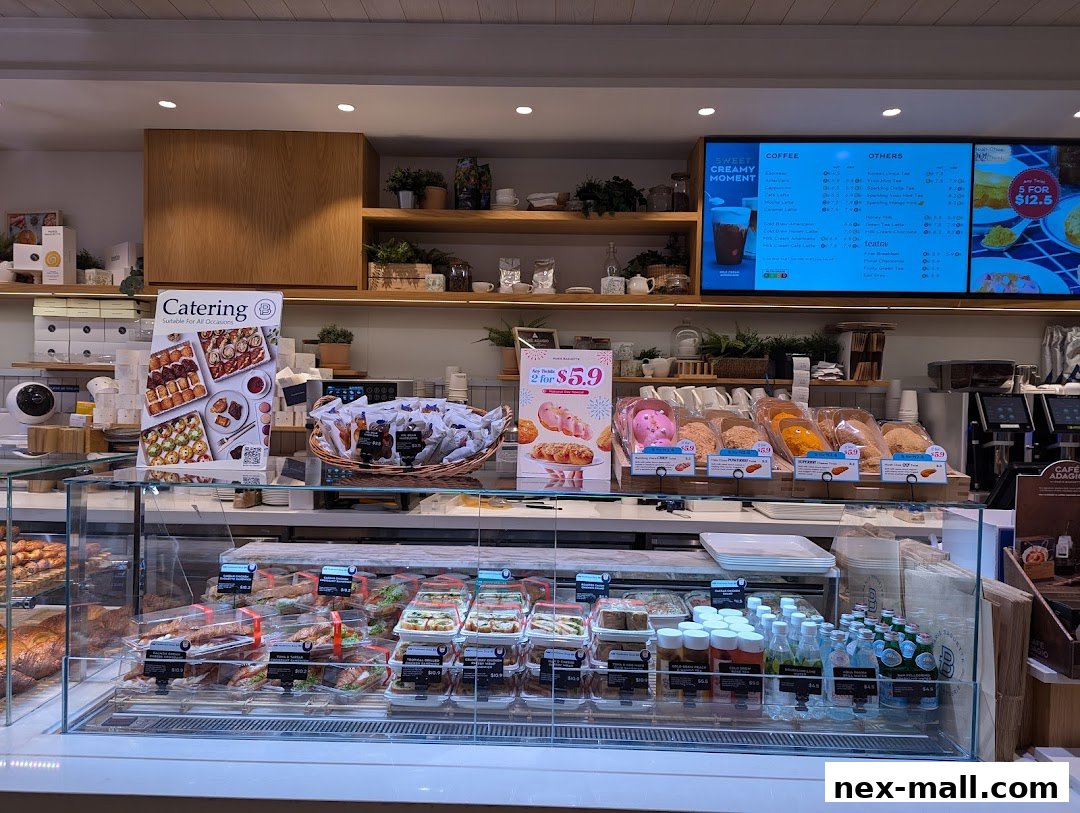 A display of baked goods, sandwiches, and drinks at Paris Baguette NEX.