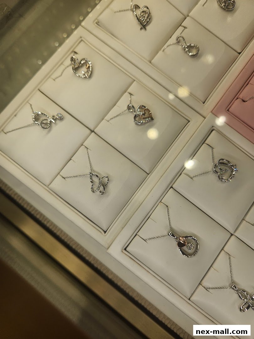 A display of various delicate necklaces with pendants, including hearts and butterflies.