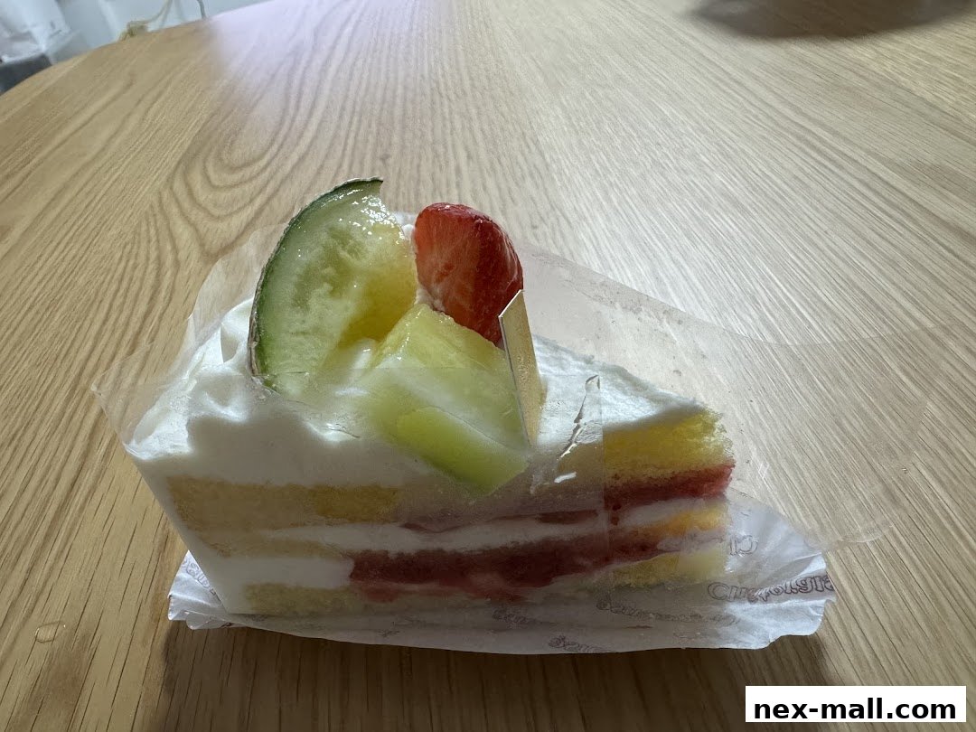 A slice of layered cake with whipped cream, fruit, and sponge cake on a wooden table.
