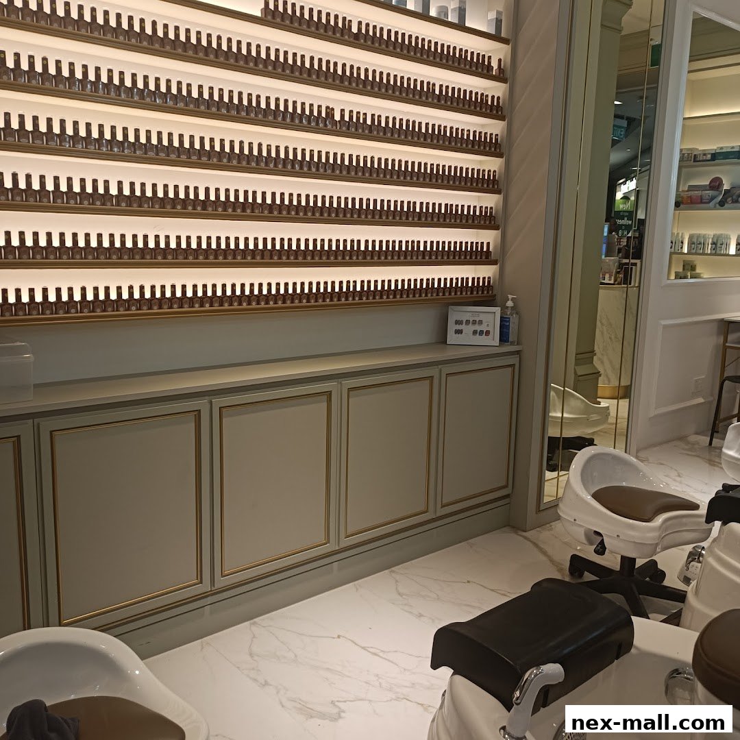 Interior of a nail salon with rows of nail polish bottles and pedicure chairs.