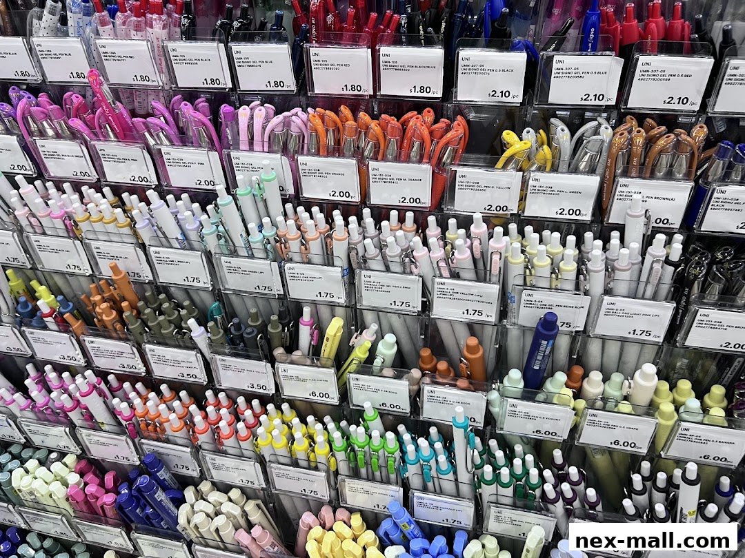 A vibrant display of colorful pens, neatly organized by color and type, with price tags.