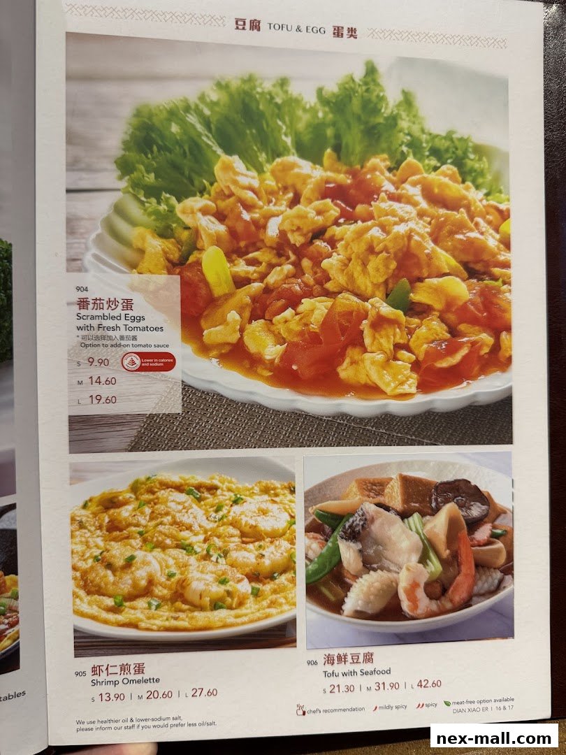 A menu page from Dian Xiao Er featuring three dishes: Scrambled Eggs with Fresh Tomatoes, Shrimp Omelette, and Tofu with Seafood.