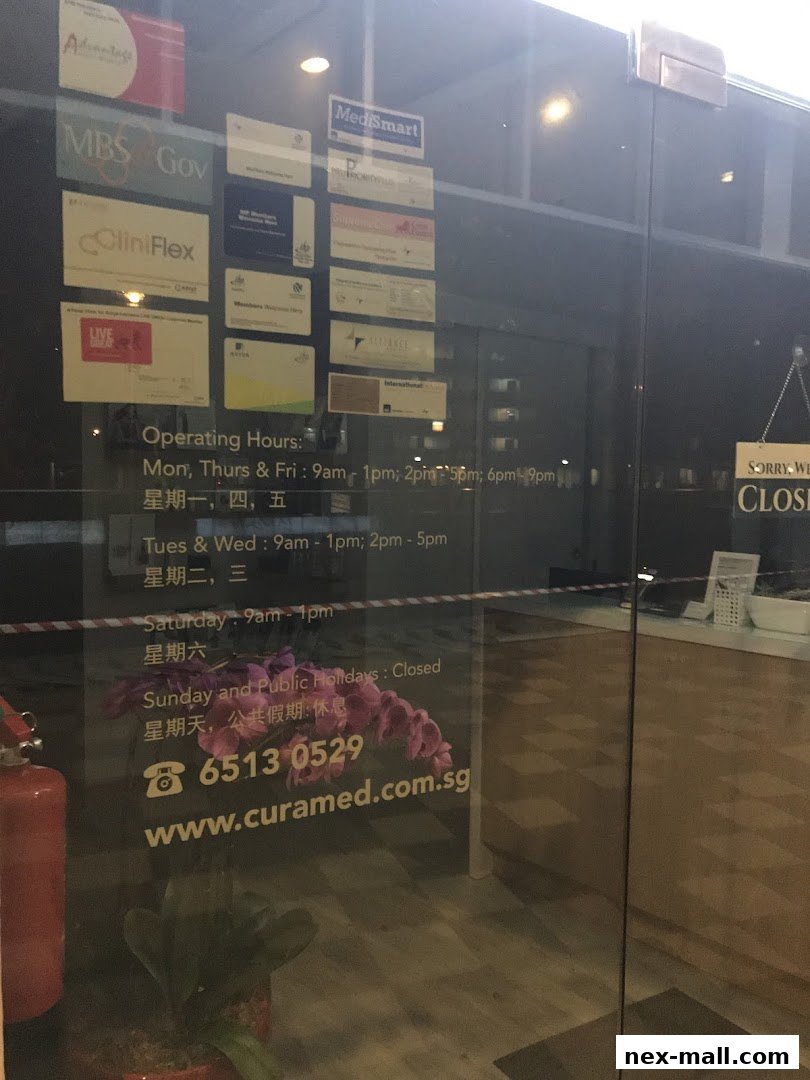 The glass door of a medical clinic with operating hours and contact information displayed.