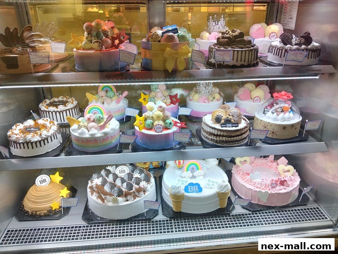 A display case filled with a variety of colorful and elaborately decorated ice cream cakes.
