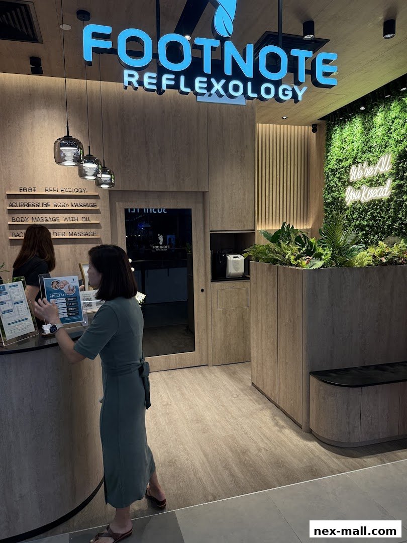 The entrance of FootNote Reflexology with a reception desk and a green wall.