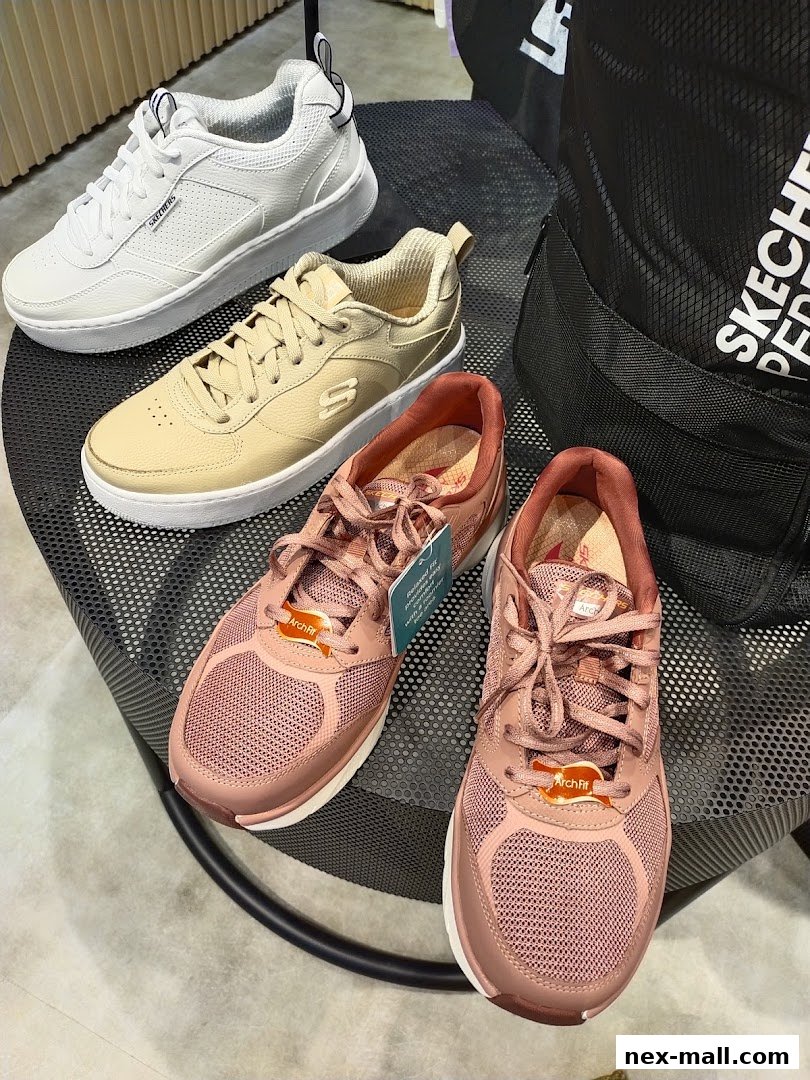 A display of Skechers shoes in various colors, including white, beige, and pink, with a black backpack.