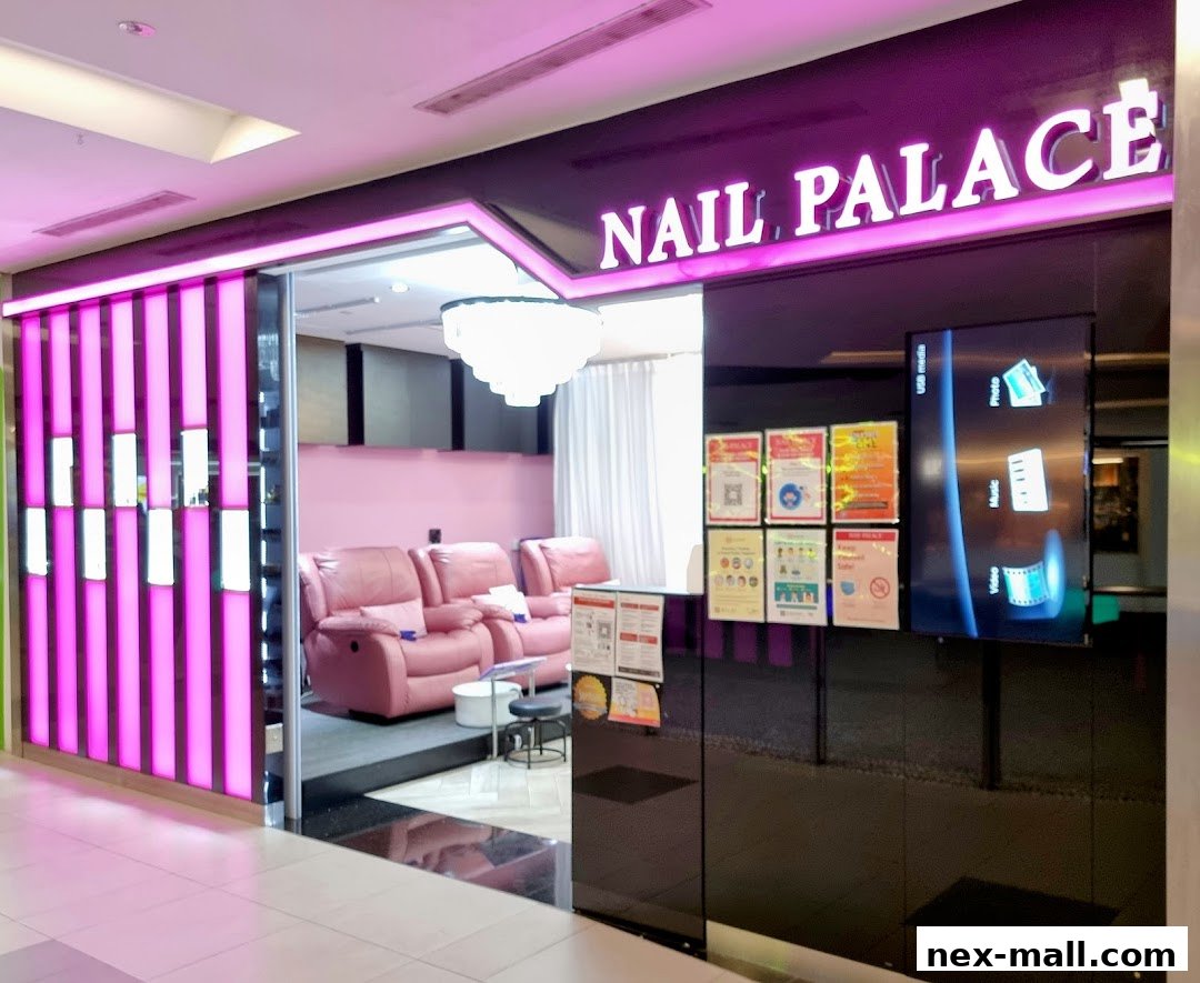 The entrance to Nail Palace, featuring pink decor, comfortable seating, and bright signage.