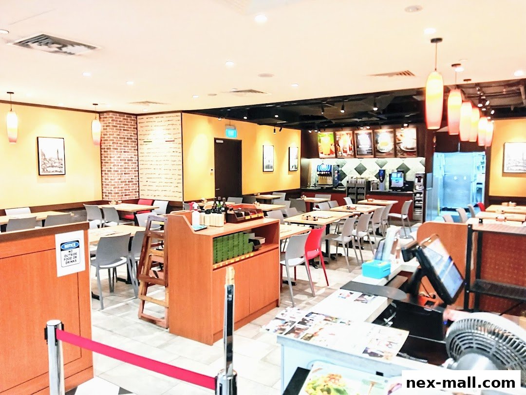 Interior view of a Saizeriya restaurant with tables, chairs, and a counter.