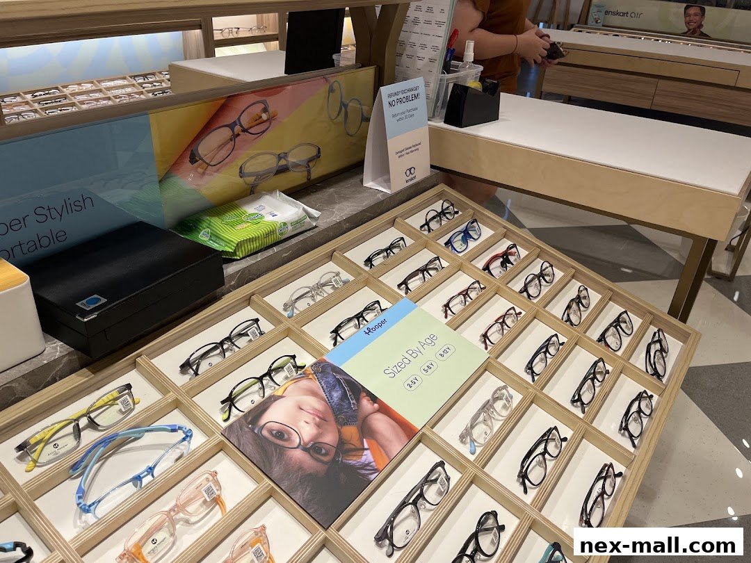 A display of various eyeglasses in wooden trays at Lenskart NEX.