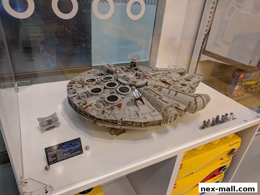 A detailed LEGO Millennium Falcon model displayed with minifigures and LEGO City boxes.