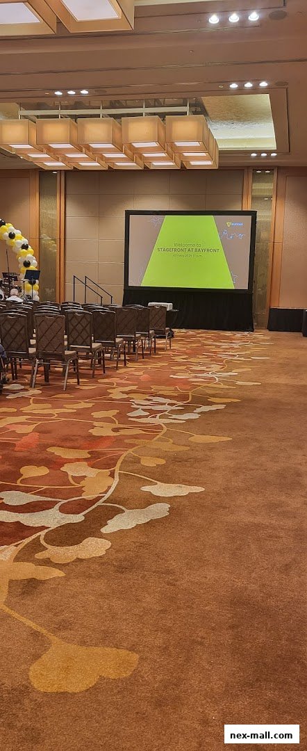 A conference room setup with chairs facing a large screen displaying a welcome message.